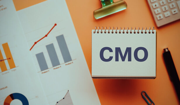 There is notebook with the word CMO. It is an abbreviation for Chief Marketing Officer as eye-catching image.