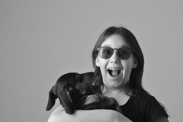 adolescente estilosa com expressão de surpresa com cachorro fofo duchshund, amor, carinho e...