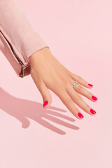 Womans hand with pink nail design. Manicure, pedicure beauty salon concept. Trendy color