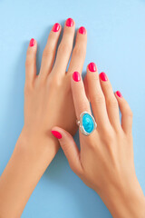 Womans hands with trendy manicure on pastel blue background. Beauty salon concept