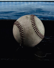 Old used baseball in water for rain game concept of sport, vertical background.