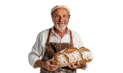 Portrait of a smiling senior baker holding a bread and wearing apron, isolated on transparent background