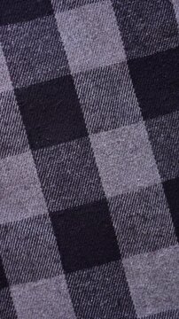 Rotating plaid flannel fabric. Checkered flannel cloth background. 4k vertical video