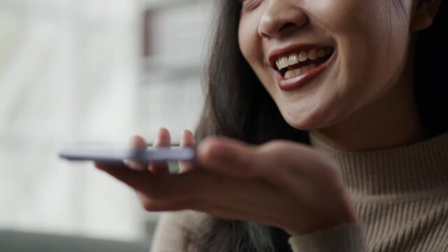 close up of woman mouth is talking and giggle with happy joy to smartphone on speakerphone with friends family or others colleague 
