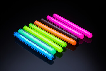 A row of colorful glow sticks on a black background.