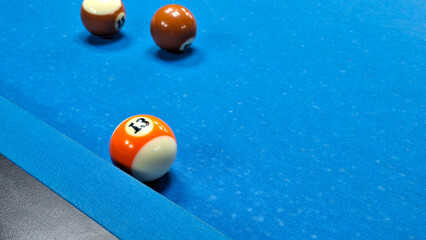 Sports game of billiards on a blue table. Multi-colored billiard balls with numbers on a pool table.