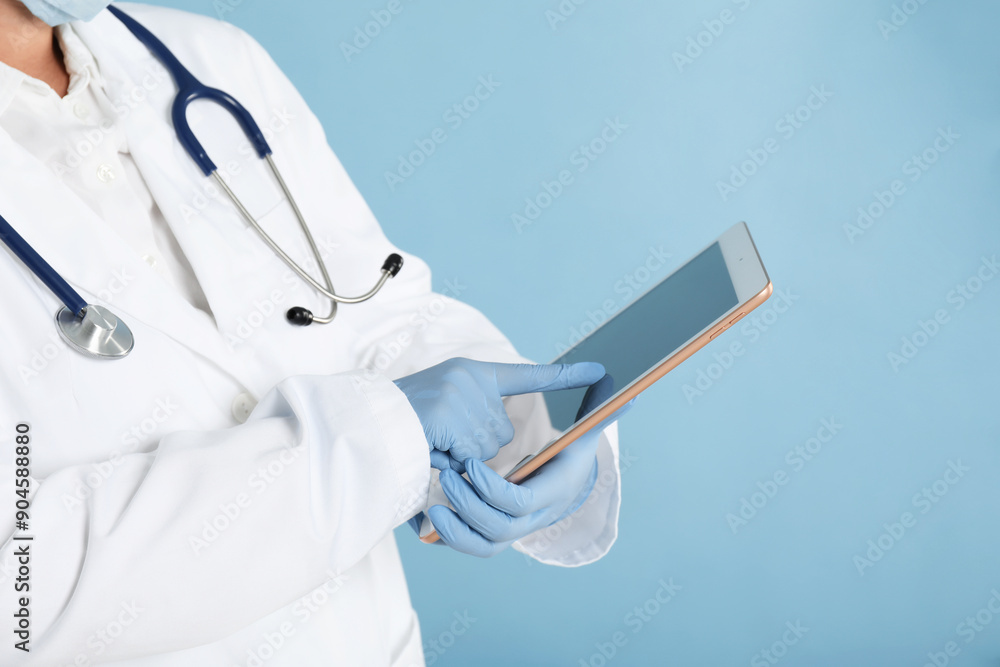 Wall mural doctor with tablet on light blue background, closeup view