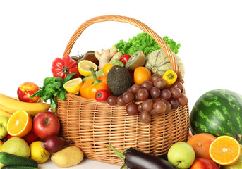 Many different fruits and vegetables in wicker basket isolated on white