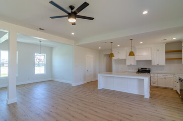 Interior living room, kitchen and dining room with laminante wood floors, white walls