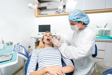 Obraz premium Female dentist examine tooth to Caucasian girl at dental health clinic. 