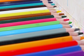 Fototapeta premium row of colored pencils on a white background