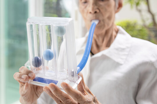 Senior patient using incentive spirometer,tool to help the lung expansion,exercise the lung,old elderly with Tuberculosis,Asthma,problem of respiratory disease,treatment,health care,medical concept