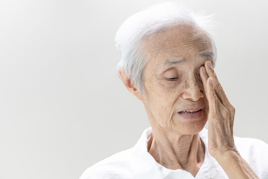 Asian senior woman with Age-related macular degeneration(AMD), degenerative of the retina or macula of the eye,blurred vision,old elderly touching her eye with hand,loss of sight,health care,medical