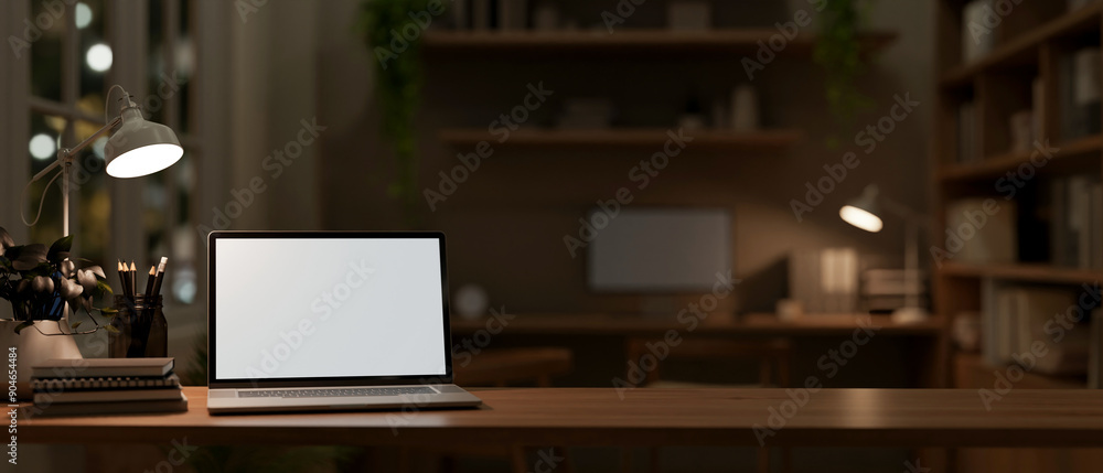 Wall mural a front view image of a laptop computer mockup on a wooden table in a dark office.