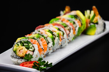 Cucumber, Spicy Salmon, and Shrimp Tempura Sushi Roll Topped with Torched Salmon, Unagi Sauce, and Spicy Mayo