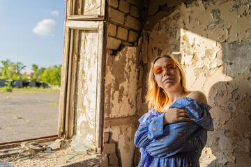 Bright Sunlight Shines Through Windows as Young Woman Poses in Abandoned Building During Golden Hour