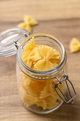 Uncooked farfalle pasta (bow tie shape) in glass jar, Italian food ingredient