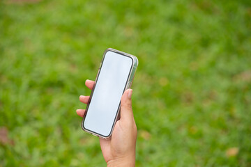 Woman's hand holds a large smartphone with a blank white screen in his hand. It shows free space for entering text.