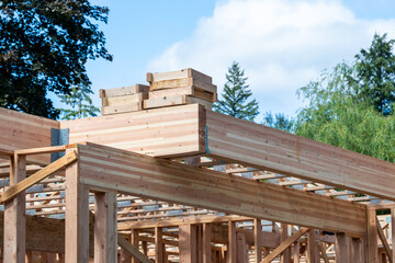 New house construction in residential neighborhood, first floor wood framing with large wood...
