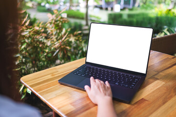 Mockup image of a woman using and touching on laptop computer touchpad with blank white desktop screen in the outdoors