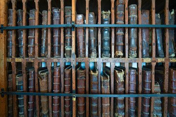 Bookshelf filled with old leather bound hard cover books. A bookcase of several, multiple large rare antique books, an aged vintage book collection. Perfect book background, concepts, layout designs.