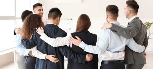 Group of business people hugging in office. Unity concept