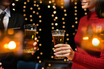 food and drink male friends are happy drinking beer and clinking glasses at a bar or pub.