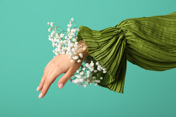 Woman with gypsophila flowers on green background. Hand care concept