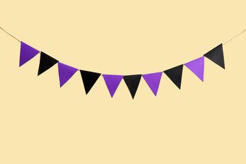 Fototapeta premium Garland made of paper flags for Halloween celebration on beige background