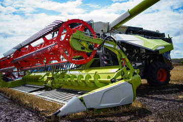 Harvesting wheat with a green combine. Farm machinery harvesting wheat crop. Green harvester in...