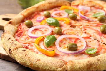 Cut delicious vegetarian pizza on wooden table, closeup