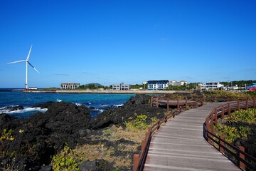 seaside walkway and far wind turbine