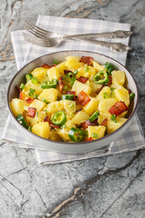Potatoes jalapeno salad with bacon, green onions in mexican style close-up in bowl on table. Vertical