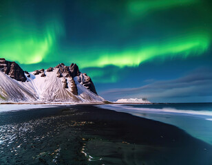 Naklejka premium Aurora borealis, northern lights over snowy mountains with ocean view 