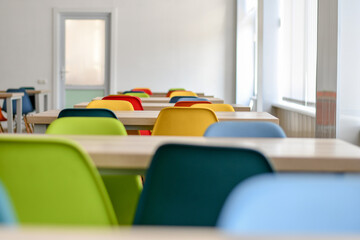 Empty school dining room or cafe with colorful chairs. Selective focus.