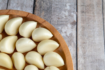 top view close up of half wooden plate filled with arranged of garlic