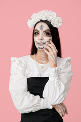 Beautiful young woman dressed as dead bride for Halloween party on pink background