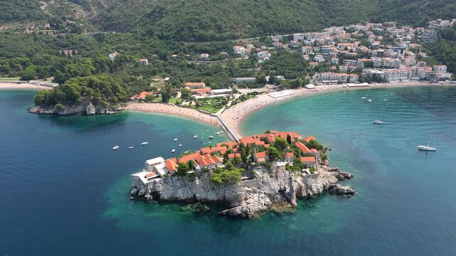 A drone flies around the island of Sveti Stefan in Montenegro on a sunny summer day