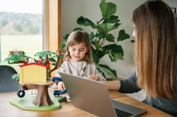 Working Mom and Daughter Engaging in Play at Home Office