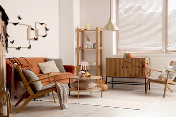 Interior of living room decorated for Halloween with red sofa and armchairs