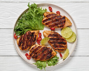 grilled chicken breasts wrapped in bacon on plate