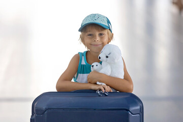 Sweet children, brothers, boys, waking hand in hand at the airport, carrying suitcases and backpacks