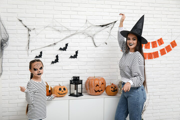 Little girl with her mother celebrating Halloween at home