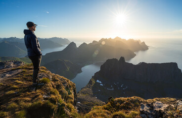 A man wachting the midnightsun on summit Grytetippen on Senja, Norway.