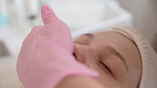 A nourishing elixir is applied drop by drop to the girl s skin in a calm and relaxing environment of a beauty salon