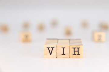Human Immunodeficiency Virus in spanish language. VIH aconym written on wooden cubes isolated on white background with copy space for text