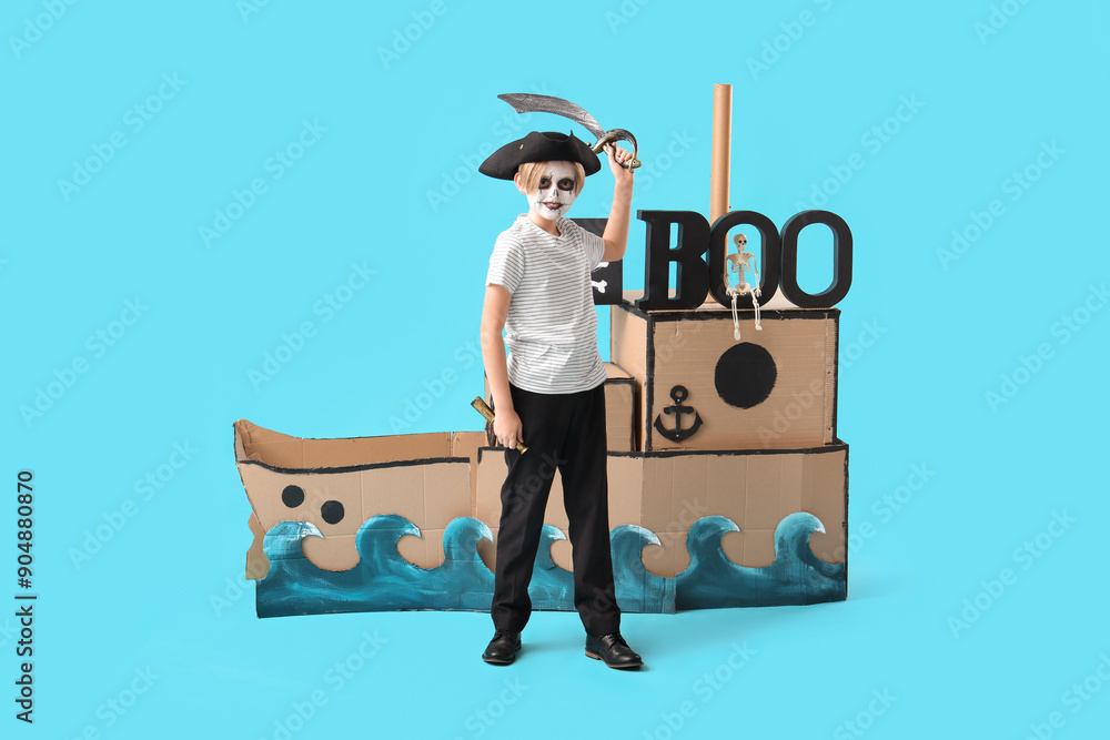 Poster little boy dressed for halloween as pirate with cardboard ship on blue background