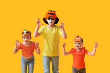 Little children dressed for Halloween on yellow background