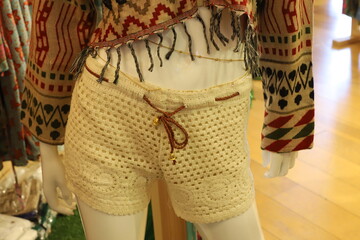 A mannequin stands in a shop window to advertise women's clothing.