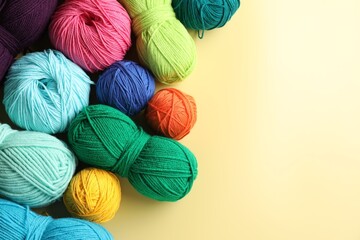 Different yarns on yellow background, flat lay. Space for text